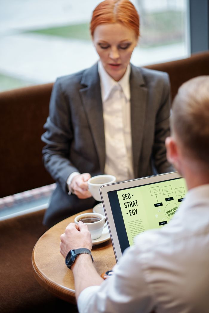 Réunion professionnelle dans un café avec un ordinateur portable affichant une stratégie SEO. Parfait pour les idées d'affaires.